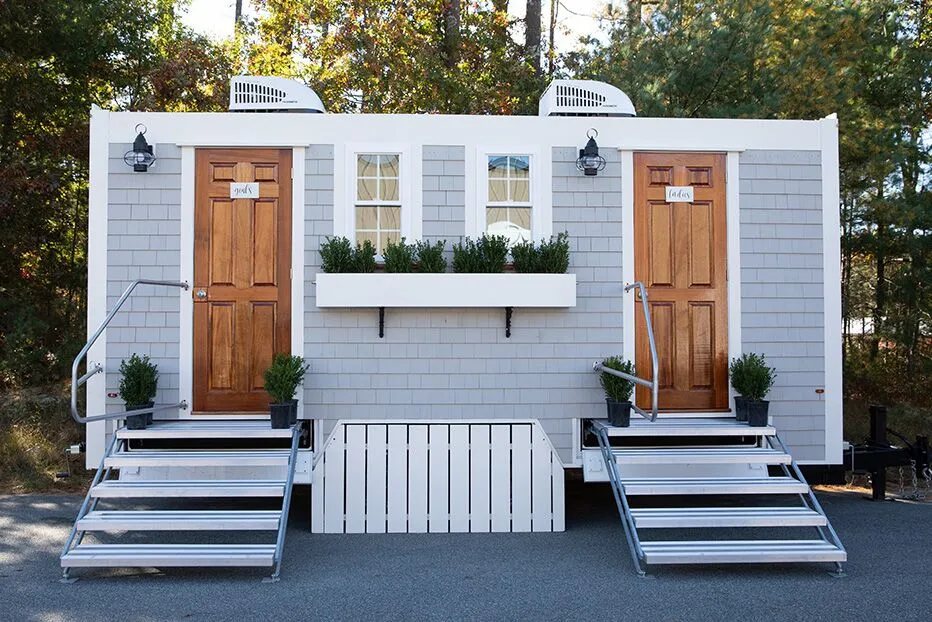 Upscale restroom trailer set up at an outdoor wedding venue